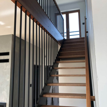 Nowoczesne schody drewniane z balustrada typu harfa